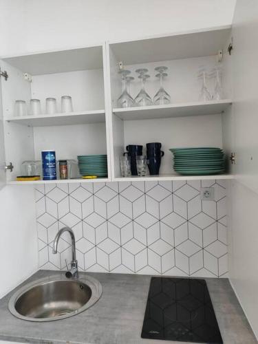 une cuisine avec un évier et un comptoir avec de la vaisselle dans l'établissement Grand volume calme centre-ville Tan1, à Cambrai
