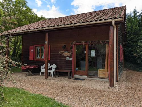 a small wooden cabin with a table and a chair at LES CHALETS DE LA VIGNE GRANDE in Saint-Floret