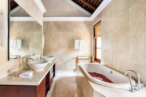 a bathroom with a large tub and two sinks at Boutique hotel villa Cantik and karma beach club in Uluwatu