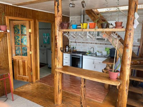 Cabaña de madera con cocina, paredes de madera y suelo de madera. en Cabañas los Martinez Ojeda, en Dalcahue