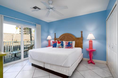 a bedroom with a bed and a balcony at Harbour House at the Inn 204 in Fort Myers Beach