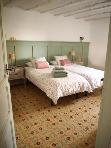 1 dormitorio con 2 camas y almohadas rosas en El Sol del Membrillo, en Corera