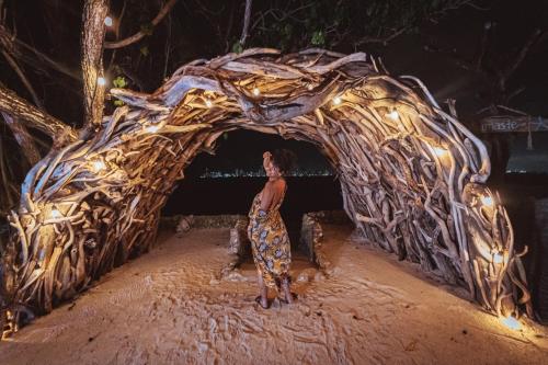 a woman standing in front of a large structure with lights at Namaste Beach Club & Hotel in Tierra Bomba