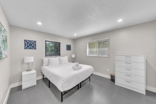 - une chambre blanche avec un grand lit et une commode dans l'établissement Coconut Bungalow - Modern 3 1 in Grove Bay, à Miami