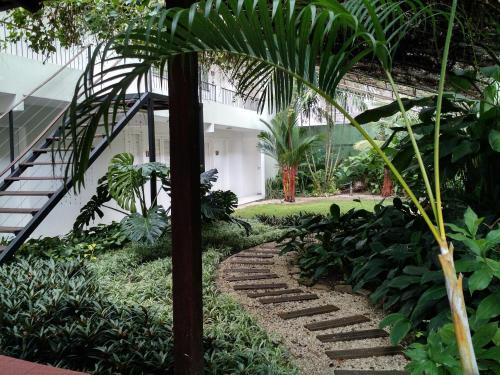 a garden with a stone path in front of a building at Ecopousada Miriti in Belém
