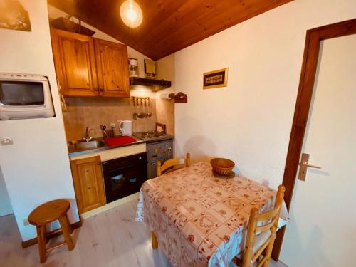 une petite cuisine avec une table et une cuisinière dans l'établissement Appartement cosy 4 pers. avec balcon et vue à La Clusaz - FR-1-459-218, à La Clusaz