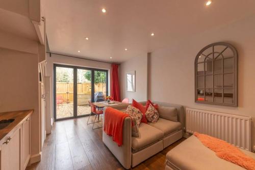 a living room with a couch and a table at Cotswold Luxury Coach House - ideal for couples, w/ EV charging in Andoversford