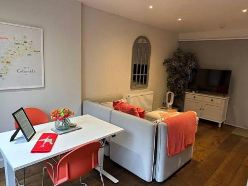 a living room with a couch and a table at Cotswold Luxury Coach House - ideal for couples, w/ EV charging in Andoversford