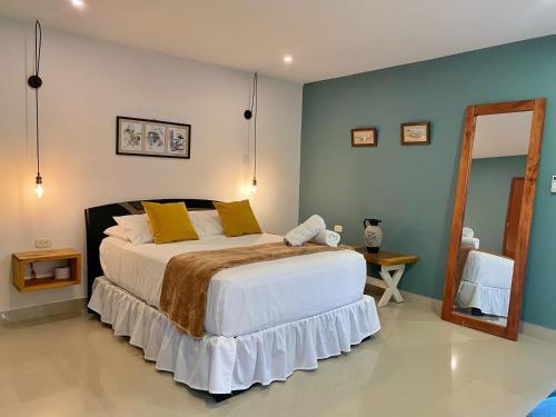 um quarto com uma cama grande e um espelho em La Casablanca Tayrona House em Calabazo