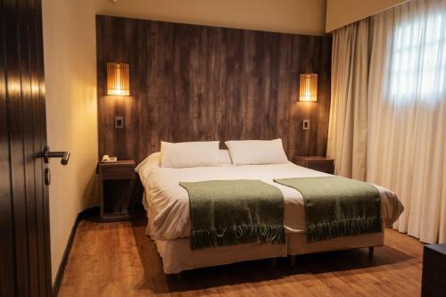 sypialnia z dużym łóżkiem i zielonym kocem w obiekcie Gran Hotel Potrerillos w mieście Potrerillos