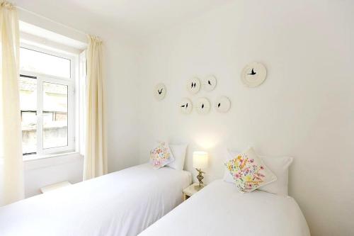 リスボンにあるSapadores · 2 bedrooms apartment Lisbon Boho Chicの窓付きの客室で、白いベッド2台が備わります。