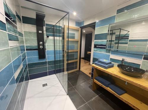 a bathroom with a sink and a glass shower at L'ANNEXE in Saint-Étienne-lès-Remiremont
