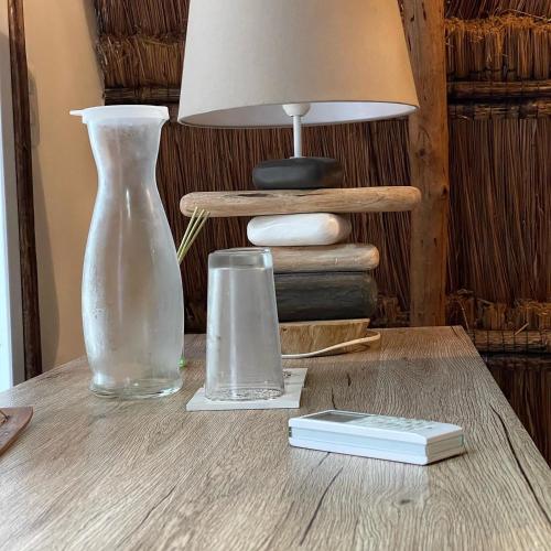 a table with two glass vases and a lamp on it at Namaste Beach Club & Hotel in Tierra Bomba