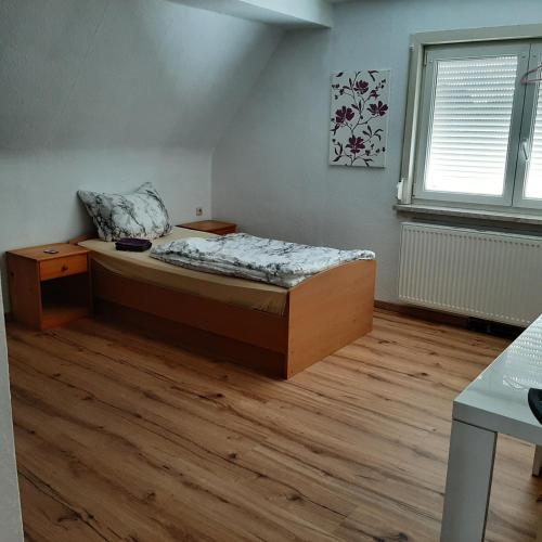 una camera con letto e pavimento in legno di Ferienhaus Hostel Zimmer Appartment in Thüringen a Schwallungen