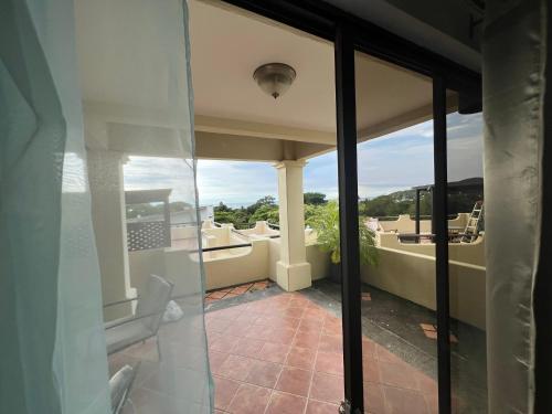 een balkon met uitzicht op de oceaan vanuit een huis bij Tropical Gardens Suites and Apartments in Coco