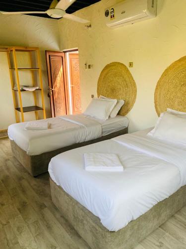 two beds sitting next to each other in a room at Riad Nizwa in Nizwa