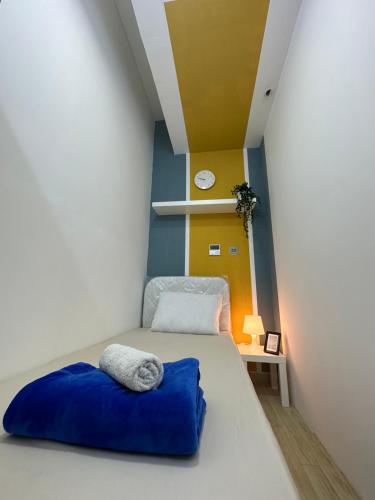 a small room with a bed with a blue pillow at Lovely Partition Room in Barsha 1 Near Metro in Dubai