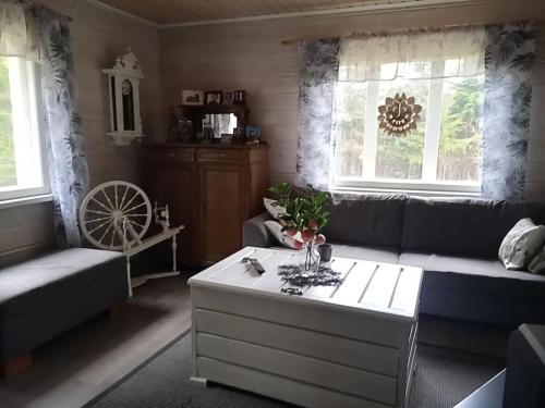 a living room with a couch and a coffee table at Onnen majoitus Haukiputaalla in Oulu