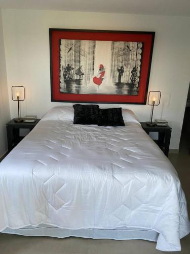 a bedroom with a white bed with two lamps at Hab. Penthouse y Terraza Privada Tango in San Bernardino