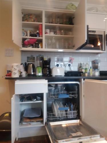 a kitchen with an open dishwasher in a kitchen at 38 Westerham in London
