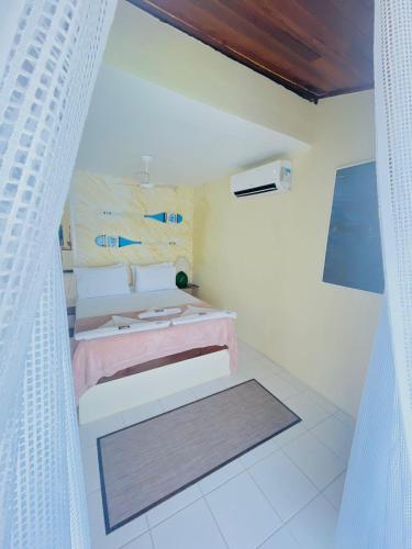 a bedroom with a bed with a pink blanket at Pousada Vista Grega in Arraial do Cabo