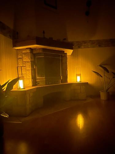 a stone fireplace with two lights in a dark room at Apartament w kamienicy in Ostróda