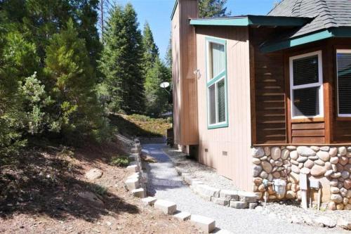 a house with a stone path next to a building at Spacious cabin with game room free WIFI & parking in Shaver Lake
