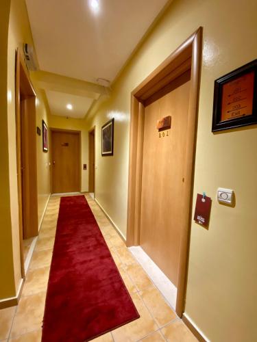 a hallway with a red carpet and a door at Appart Hôtel Oleandro in Casablanca