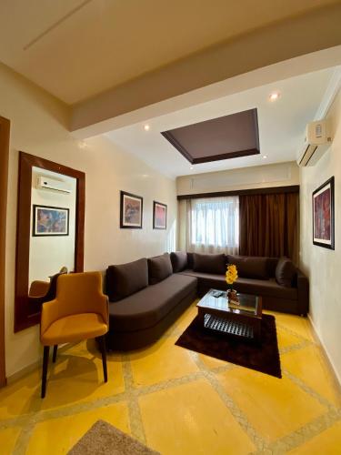 a living room with a couch and a table at Appart Hôtel Oleandro in Casablanca