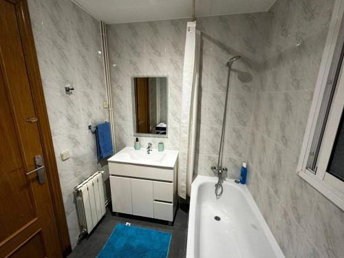 a bathroom with a tub and a sink and a bath tub at Habitaciones acogedoras in Barcelona