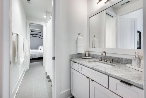 een witte badkamer met een wastafel en een spiegel bij Elegant Spacious Furnished w Garage and Fenced Yard in Nashville