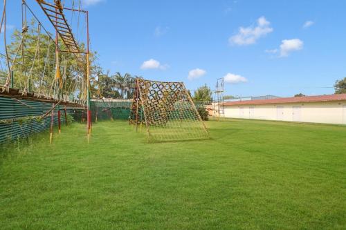 a playground with a net on a grass field at Palette - JPS Residency in Gurgaon