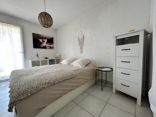 une chambre avec un grand lit et une commode dans l'établissement « Terrasse Monticelli » by les Clefs de Charlotte, à Vitrolles