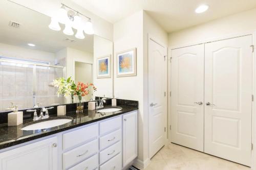 een badkamer met 2 wastafels en een grote spiegel bij Elegant 5 Bedroom Pool Home in Kissimmee