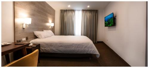 a hotel room with a large bed and a desk at LA TERRAZA INN in Huancavelica
