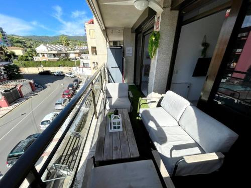 einen Balkon mit weißen Möbeln und Straßenblick in der Unterkunft Apartemento piscina centro calella 3 min playa in Calella