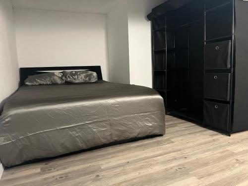 - une chambre avec un lit et une commode noire dans l'établissement Appartement cosy proche gare, à Toulouse