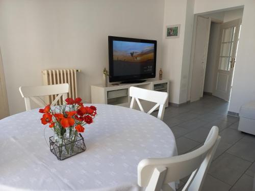 une table blanche avec un vase de fleurs sur elle dans l'établissement Aix en Provence - Rotonde - Cours Mirabeau, à Aix-en-Provence