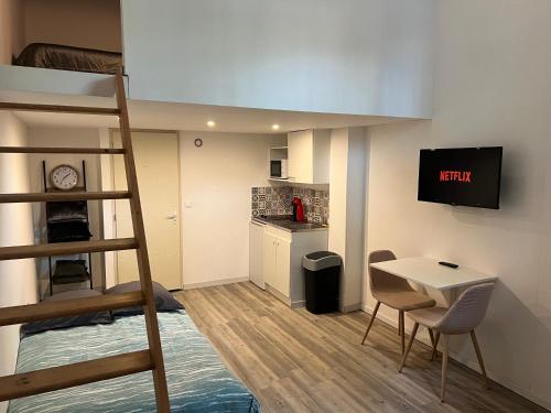 Cette petite chambre comprend des lits superposés, une table et des chaises. dans l'établissement Appartement cosy proche gare, à Toulouse