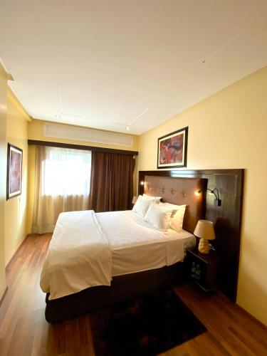 a bedroom with a large bed and a window at Appart Hôtel Oleandro in Casablanca