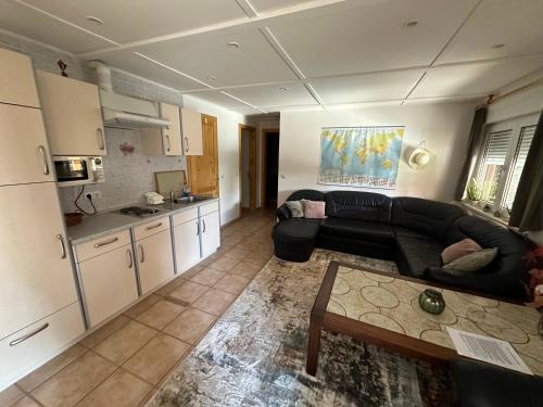 a living room with a black couch and a kitchen at Regina Ranch in Igal