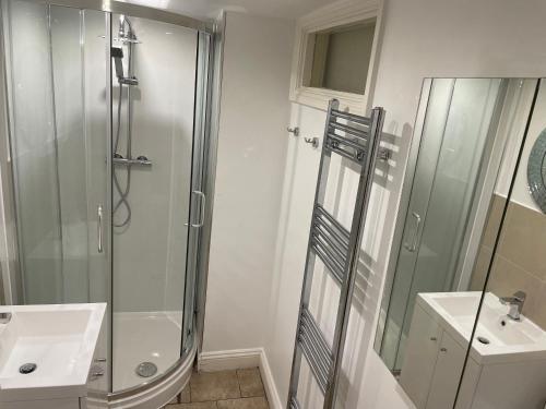 a bathroom with a shower and a sink at Griffin House Holiday Apartments in London