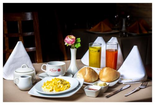 a table with a plate of breakfast food and drinks at LA TERRAZA INN in Huancavelica