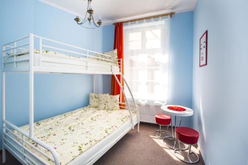 a bedroom with a bunk bed and two red chairs at Hostel Freedom in Toruń