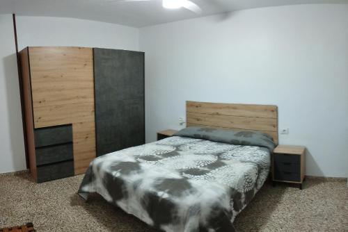 una camera da letto con un letto grande e una testiera in legno di Lecoron ad Águilas