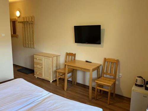 sypialnia ze stołem, krzesłami i telewizorem w obiekcie Pokoje pod Gubałówką w Zakopanem