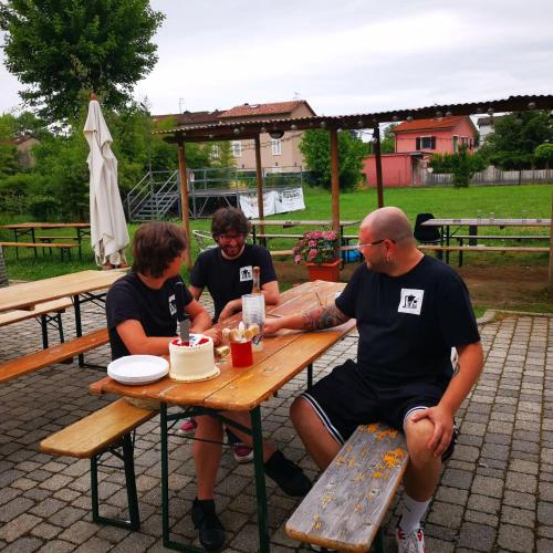 a group of people sitting at a picnic table at Ostello La Salana in Capannori