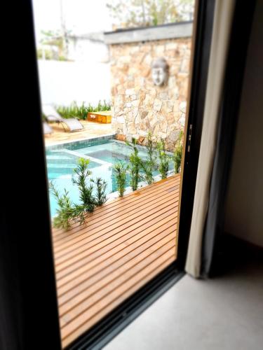 a view of a swimming pool from a window at Pousada Kirana in Praia do Rosa