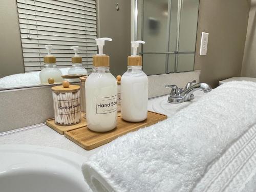 a bathroom with three bottles of soap and a sink at 7Pines Retreat in Omaha