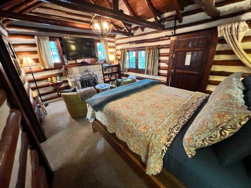 a bedroom with a bed in a log cabin at Sherwood Court Cottages in Eureka Springs